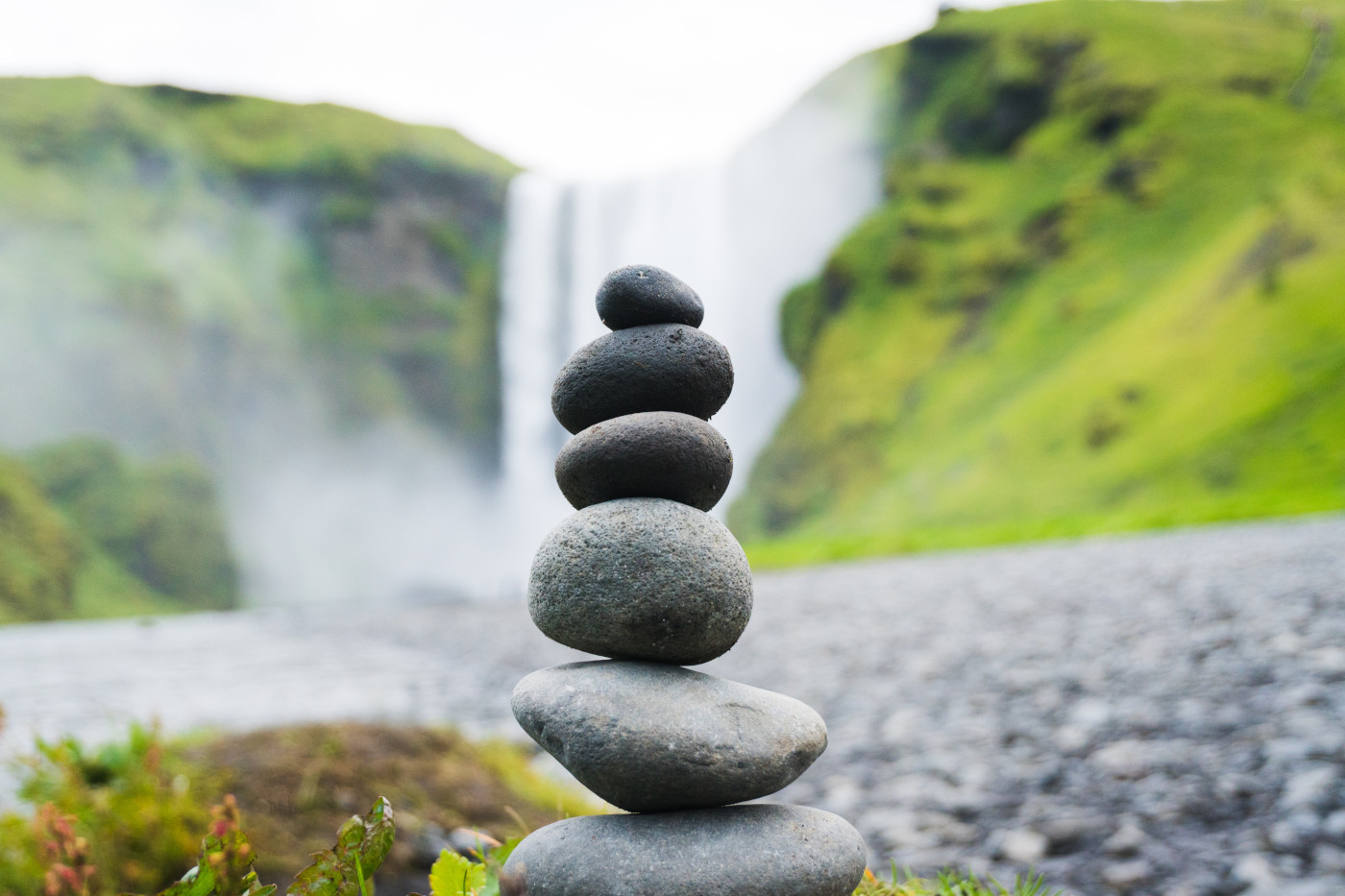 Stacked rocks in front of waterfall